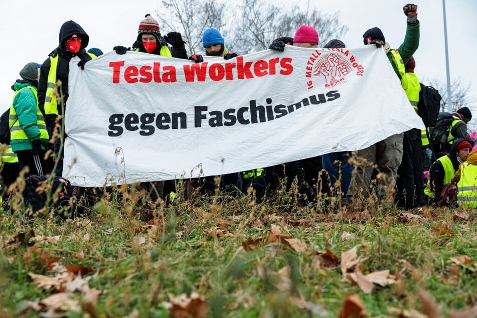 Demonstrators protesting against Germany's far-right Alternative for Germany party hold a banner reading "Tesla workers against fascism."