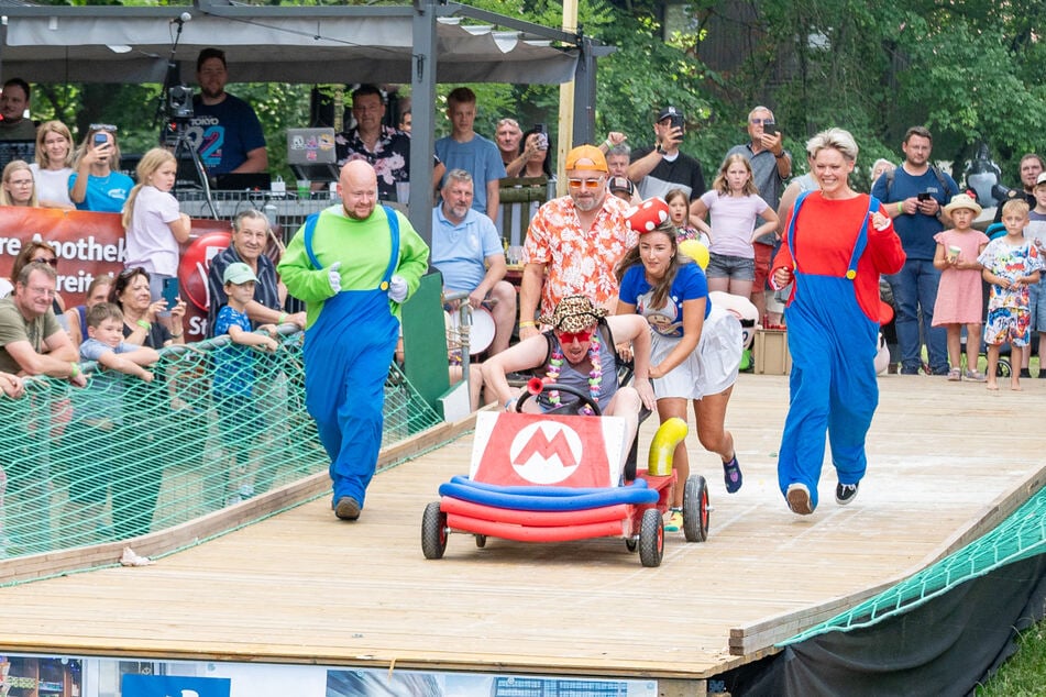 Das Team "Super Mario Kart" schiebt seinen Rennwagen in das Wasserbecken.