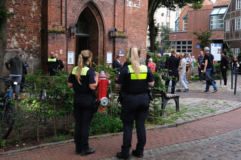 Polizistinnen standen am Dienstag vor der St.-Wilhadi-Kirche während Gäste zu einer Trauerandacht für die Opfer nach den Schüssen in einer Jugendhilfeeinrichtung kamen.