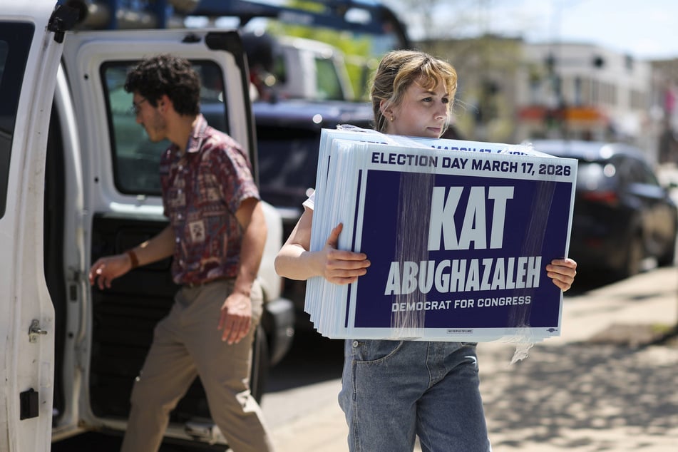 Congressional candidate Kat Abughazaleh carries yard signs into her campaign office in the Rogers Park neighborhood of Chicago on May 6, 2025.