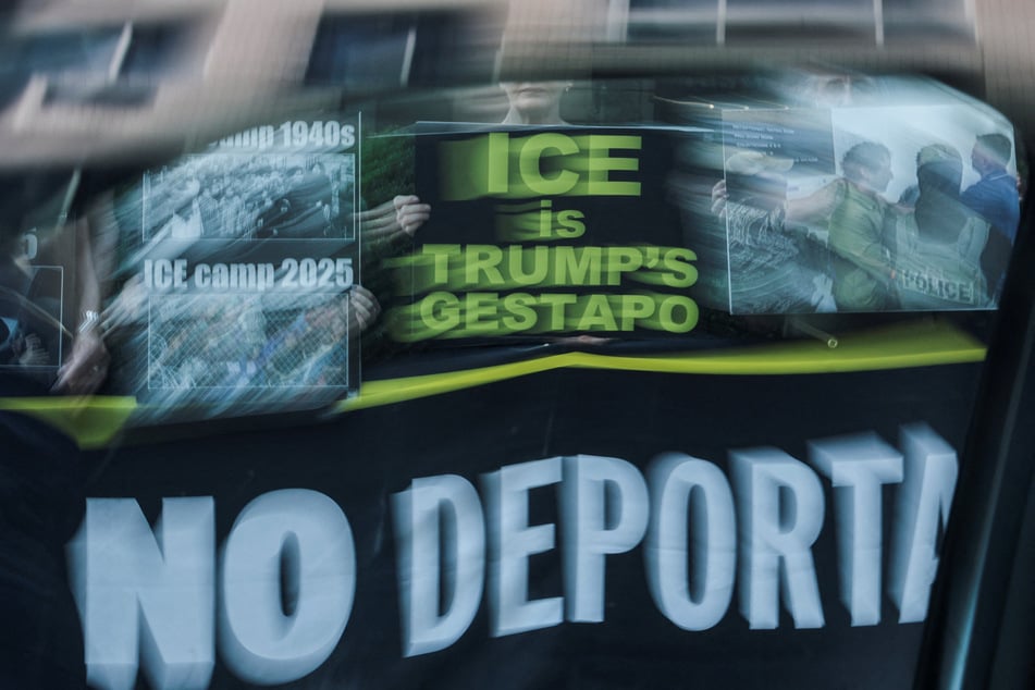 People hold signs during a silent vigil protesting US Immigration and Customs Enforcement outside the US immigration court in Manhattan, New York City, on July 24, 2025.