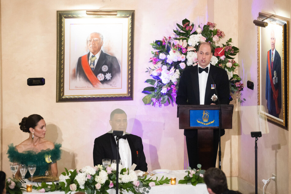 Prince William (r.) discussed his "profound sorrow" over the "atrocity" of slavery at a dinner hosted by the Governor General, accompanied by Prime Minister Andrew Holness (c.) and Kate Middleton (l.), on day five of his Royal Tour of the Caribbean.