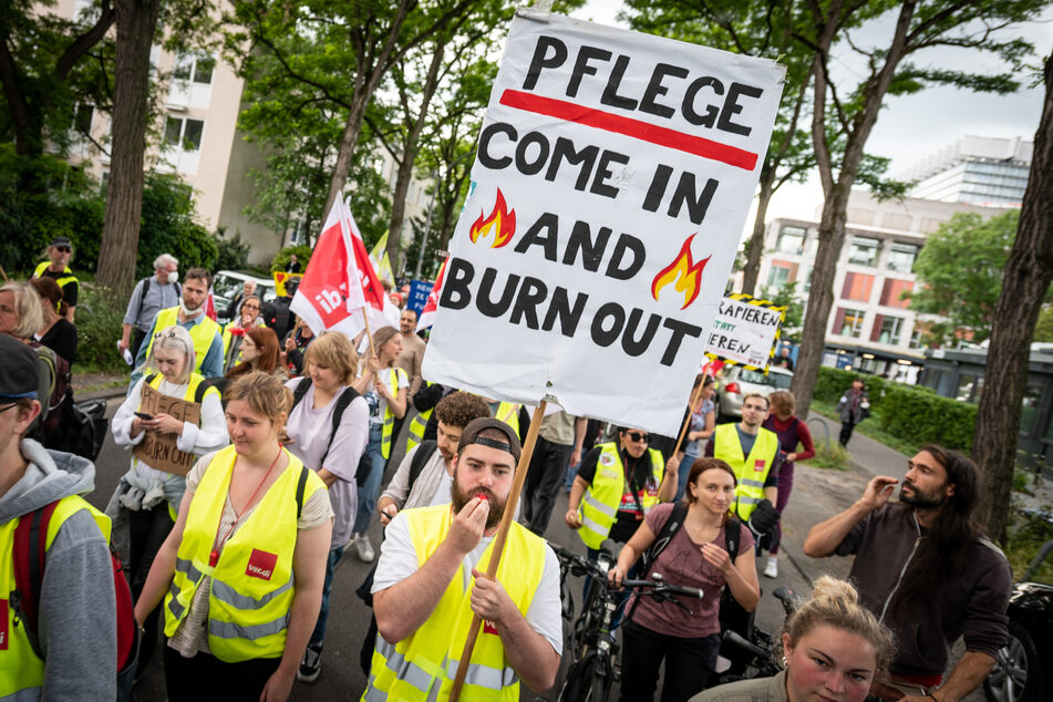 Mit einem Plakat "Pflege - come in and burn out" nahmen Pflegekräfte im Sommer an einer Demonstration teil.