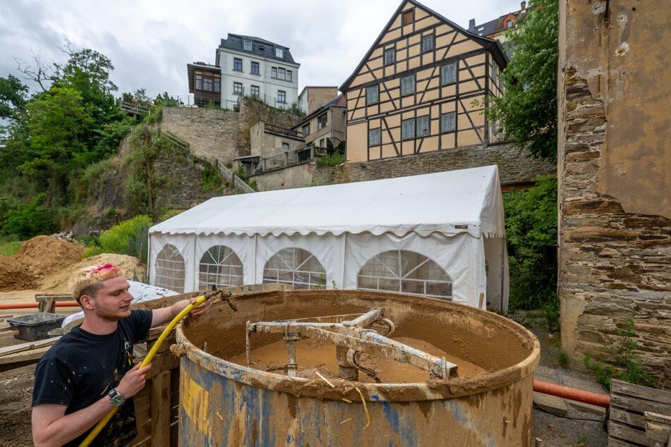 Timon Schubert (20) rührt Lehm-Unterputz an, der auf die Wände der Fachwerkhäuser aufgetragen wird.