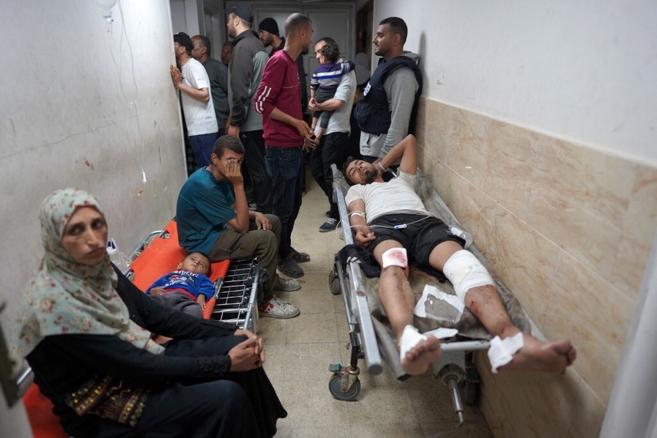 An injured Palestinian man lies on a stretcher in a corridor at the Al-Aqsa Martyrs Hospital in Deir al-Balah.