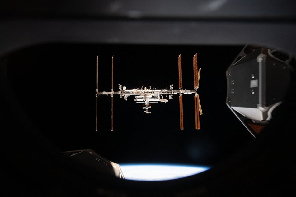 This handout image released by Nasa on September 19, 2024 shows the International Space Station pictured from inside a window aboard the SpaceX Crew Dragon Endeavour during a fly around of the orbiting lab that took place following its undocking from the Harmony module’s space-facing port on November 8, 2021.