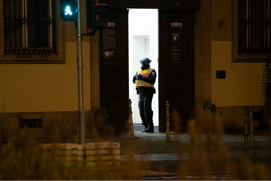 Ein Polizeibeamter steht mit gezogener Waffe im Eingang der Alte Münze in Berlin-Mitte.