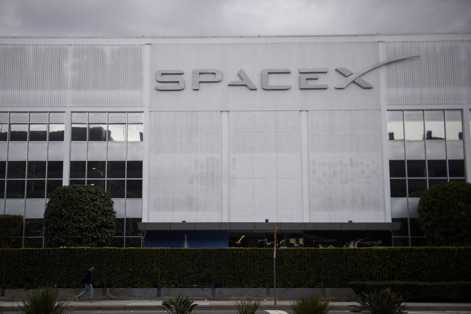 A pedestrian walks past the Space Exploration Technologies Corp. (SpaceX) headquarters on January 28, 2021 in Hawthorne, California.