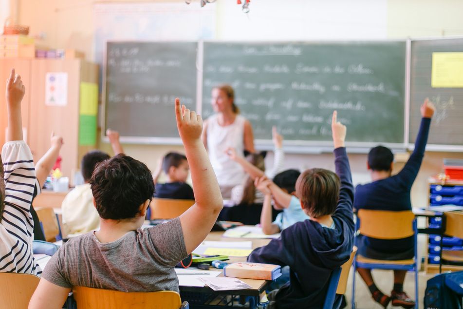 Viertklässler einer Grundschule melden sich während des Unterrichts.