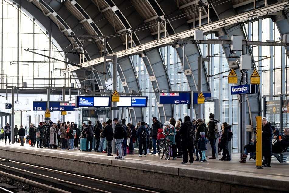 Am Alexanderplatz in Berlin warten Fahrgäste auf den nächsten Zug.