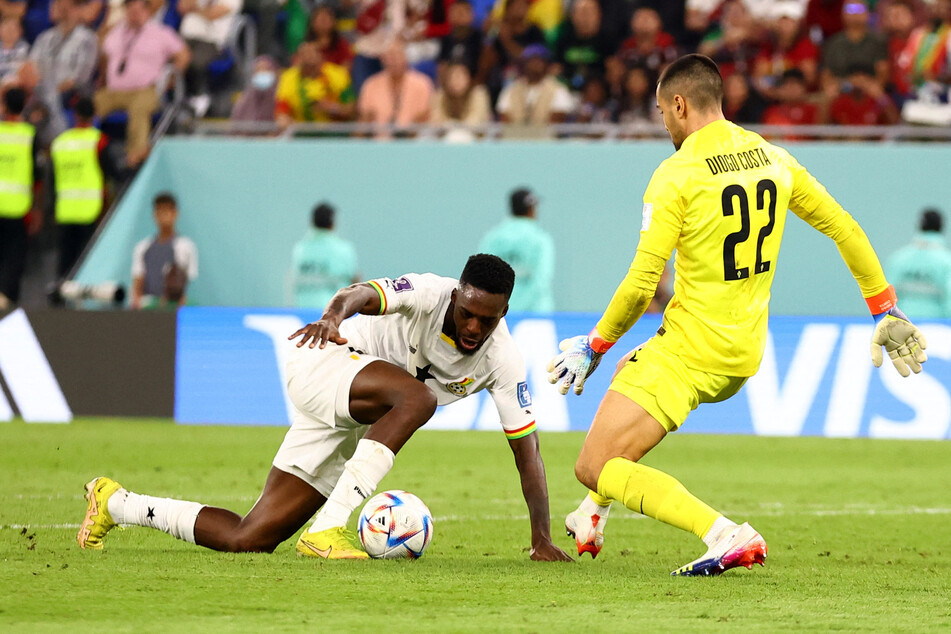 Ghana's Iñaki Williams (l.) slips at the crucial moment, just as he's about to steal the ball off Portugal goalkeeper Diogo Costa.
