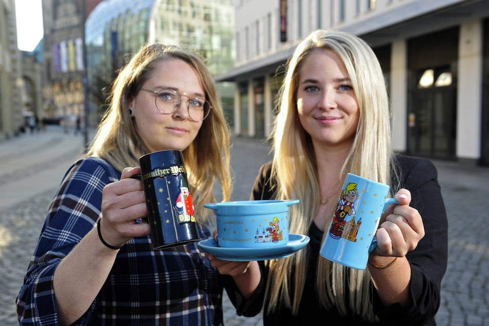 Kathleen Herold (l.) und Lucy Auerbach vom Marktwesen zeigen die neuen Glühweintassen.