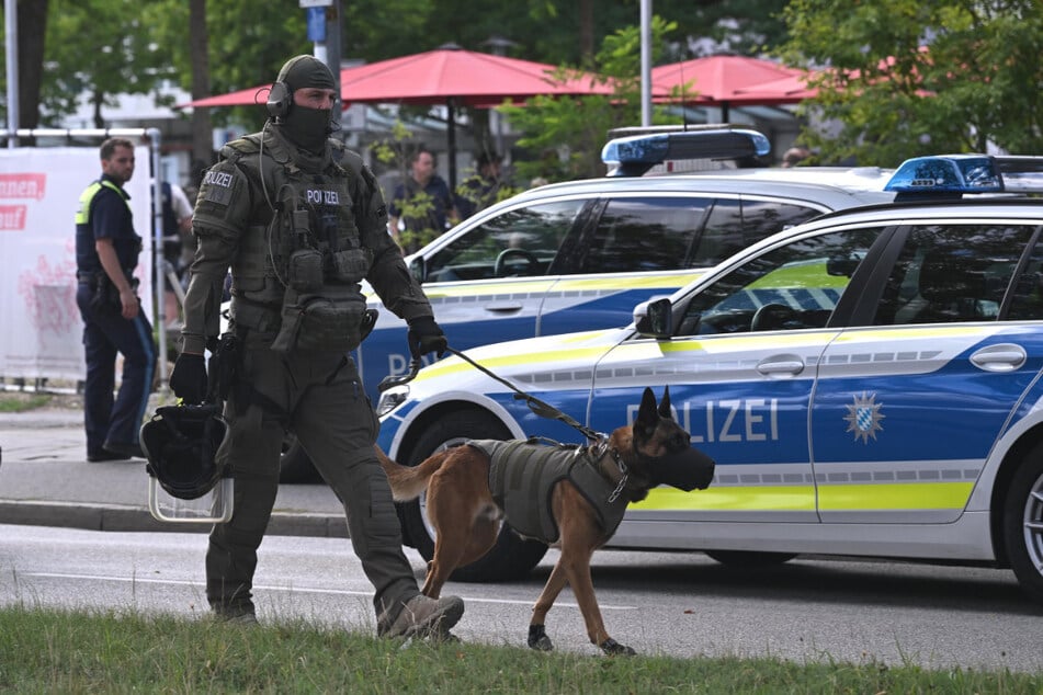 Ein Polizist ist mit einem Diensthund im Einsatz. Bei einem Messerangriff in einer Bankfiliale in Regensburg ist ein Mann ums Leben gekommen.