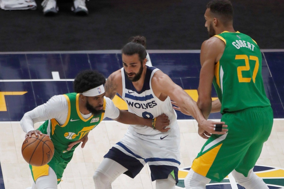Ricky Rubio (c.) of the Minnesota Timberwolves in action against Mike Conley of the Utah Jazz.