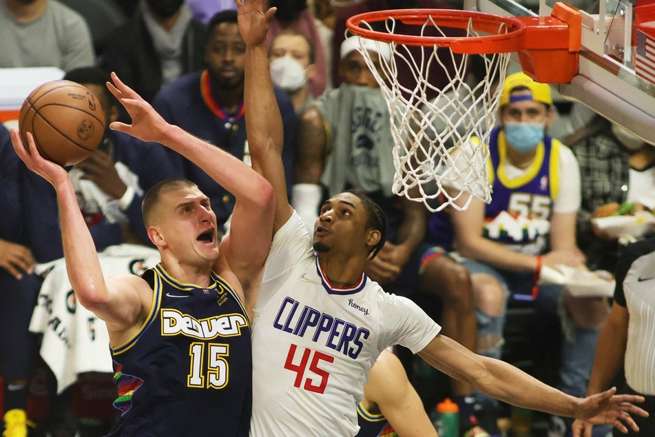 The Denver Nuggets' Nikola Jokić (l.) goes up against the Clippers' Keon Johnson.