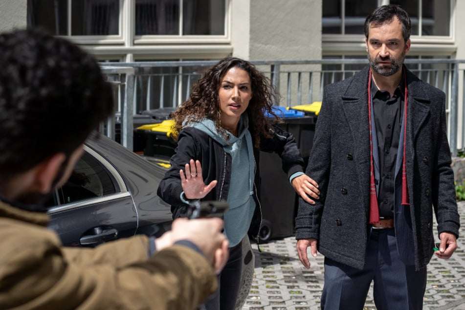 Kim holt ihren Vater von der Arbeit ab, da richtet plötzlich ein Mann eine Waffe auf ihn. Was haben die beiden miteinander zu tun?
