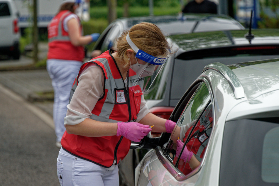 Eine Mitarbeiterin spritzt bei einer Drive-in-Impfaktion in Meerbusch (NRW) eine Dosis Impfstoff in den Arm eines Fahrers, nun läuft das Projekt auch in Berlin an.