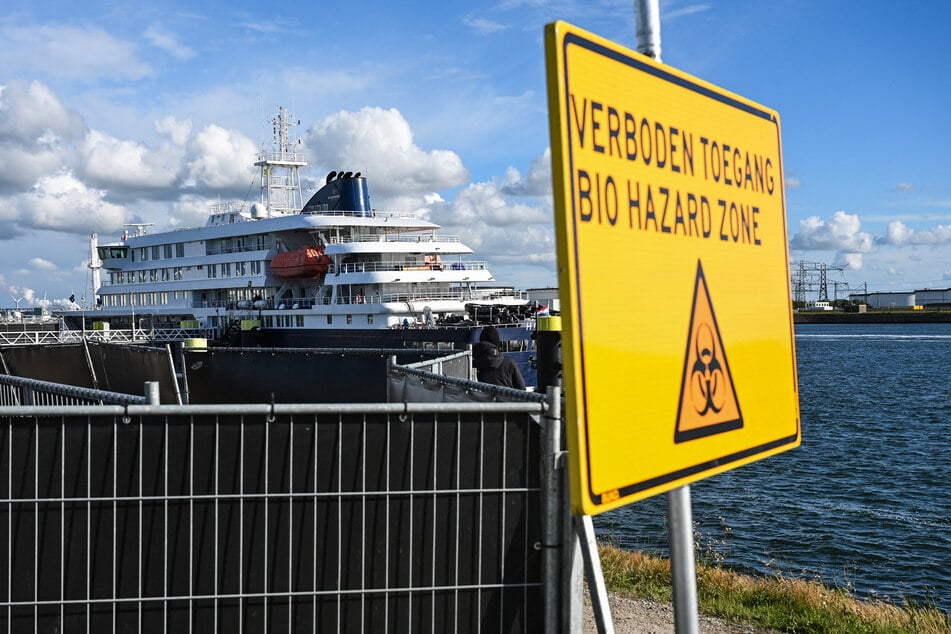A sign reading "Bio hazard zone" is pictured with the Dutch hantavirus-hit cruise ship MV Hondius in the background at the port of Rotterdam on May 18, 2026.