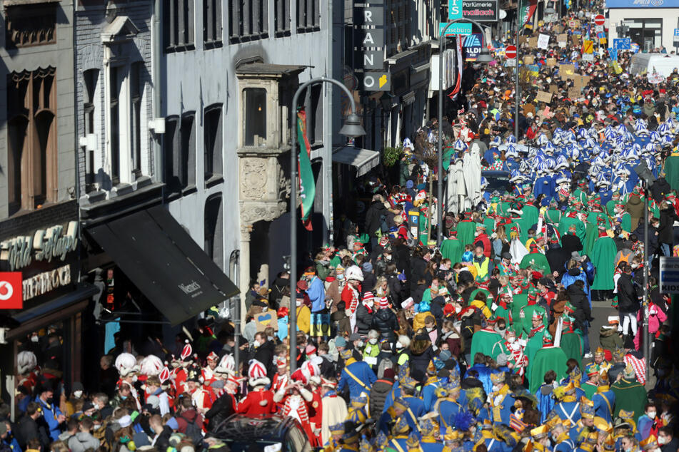 Karnevalisten ziehen am Rosenmontag durch die Kölner Straßen.