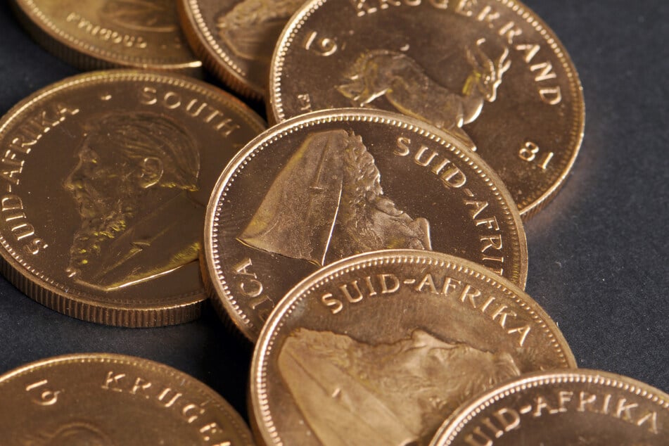 Krügerrand-Goldmünzen liegen auf einem Tisch.