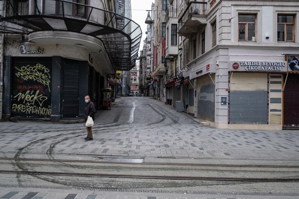 Ein Mann mit Schutzmaske steht in der leeren Istiklal Caddesi (Unabhängigkeitsstraße).