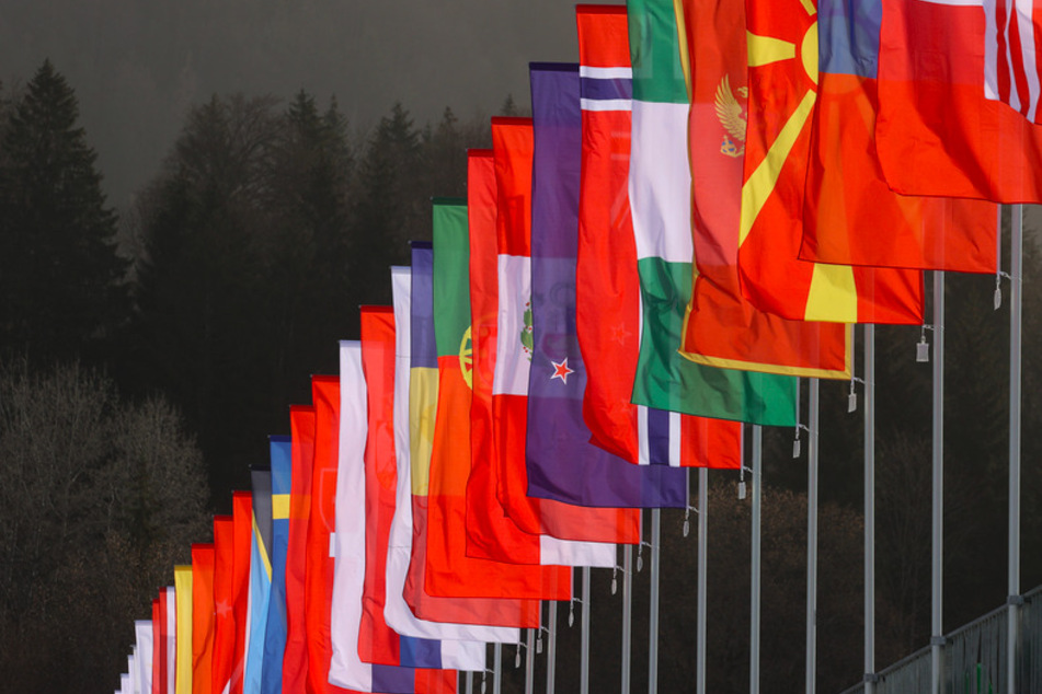 Fahnen verschiedener Nationen säumen die Zuschauertribüne in Oberstdorf.