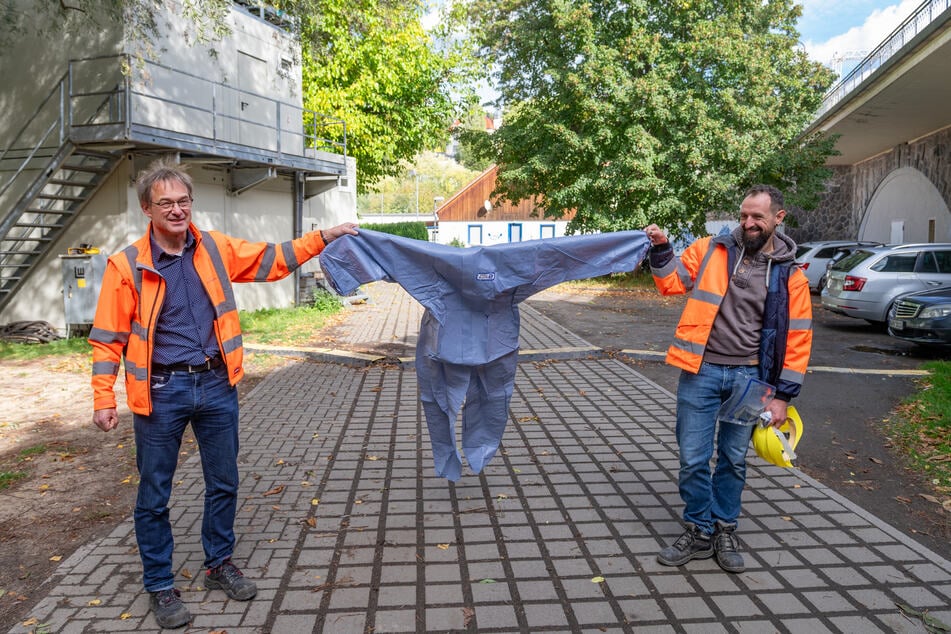 Bauüberwacher Christoph Nollau (57, l.) und Projektleiter Robert Bauch (40) zeigen einen der Schutzanzüge, den die Arbeiter tragen müssen.