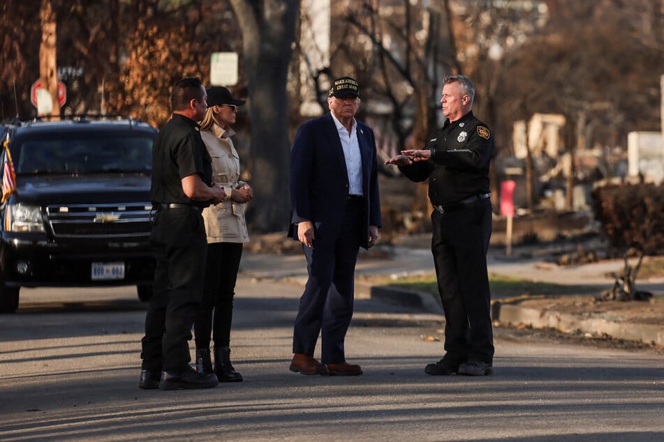 President Donald Trump and first lady Melania Trump walk with fire officials as they tour the Pacific Palisades neighborhood that was damaged by the Palisades Fire in Los Angeles, California.