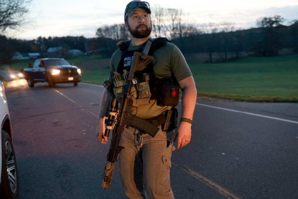 Ein Polizist mit taktischer Ausrüstung hält Ausschau nach Robert Card.