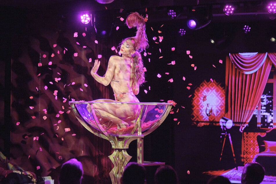 Erotischer Seegangsanzeiger: Jessara tanzt in der Burlesque-Show sinnlich in einem überdimensionalen Champagnerglas. Bei ruhiger See kann sie dabei aufstehen, ansonsten bewegt sie sich elegant in der Hocke.