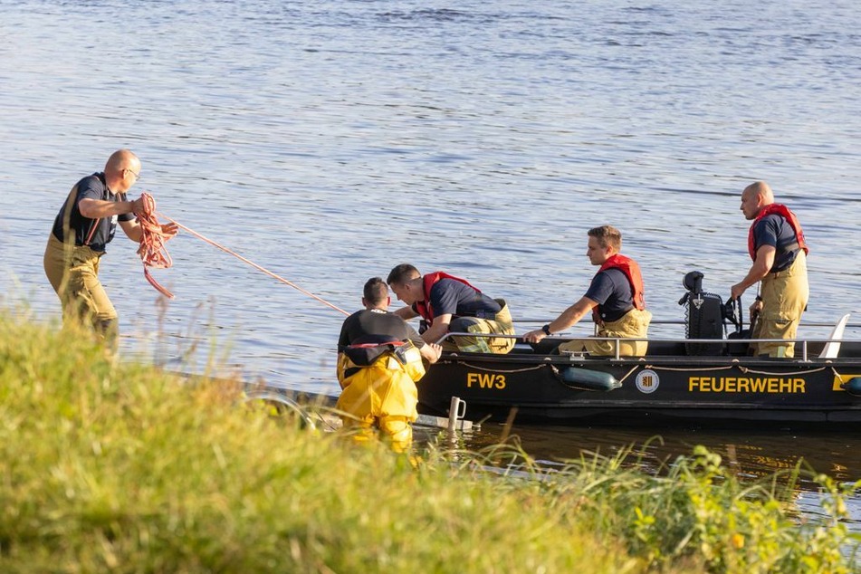 Feuerwehrleute kehren ans Ufer zurück.