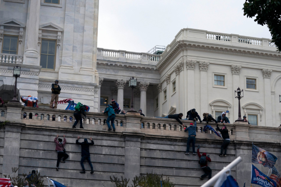 Anhänger von Präsident Donald Trump klettern in Washington auf die Westwand des US-Kapitols.