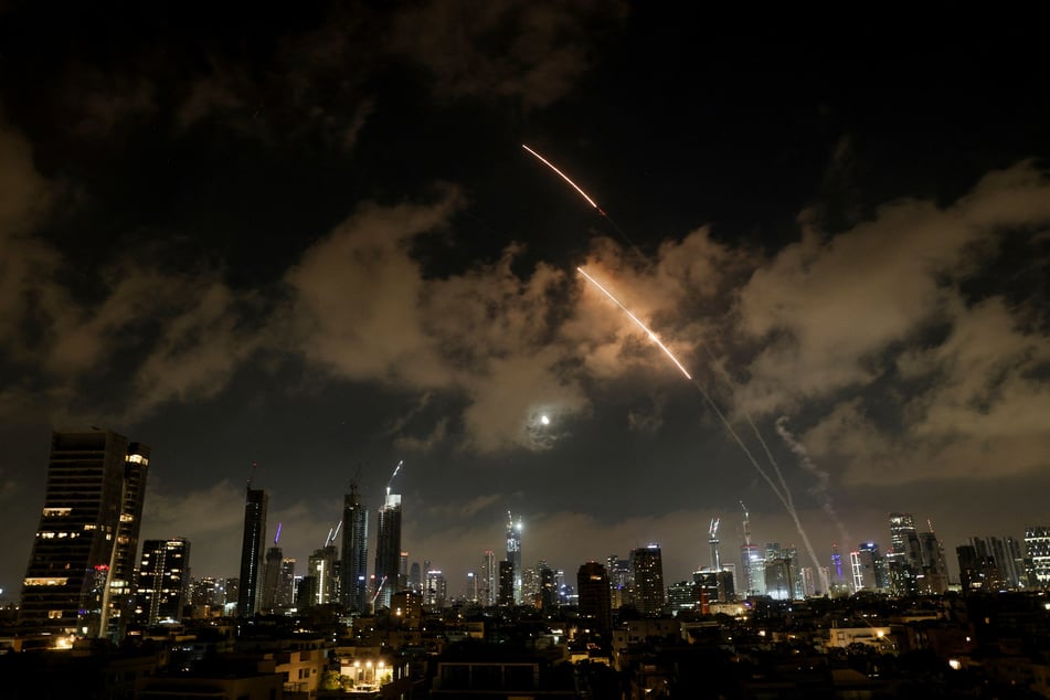 An anti-missile system operates as missiles are launched from Iran, as seen from Tel Aviv, Israel, on June 18, 2025.