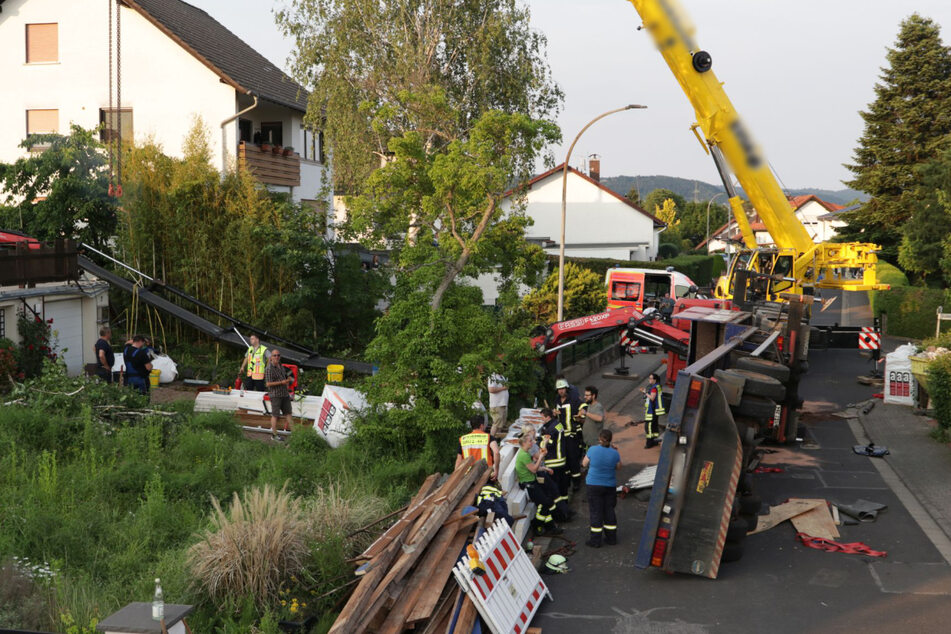 Lastwagen mit Ladekran kippt um und kracht auf Wohnhaus