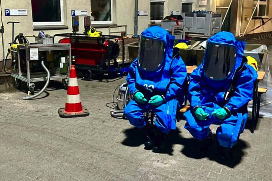 Zwei Feuerwehrleute warten in Schutzanzügen auf ihren Einsatz.