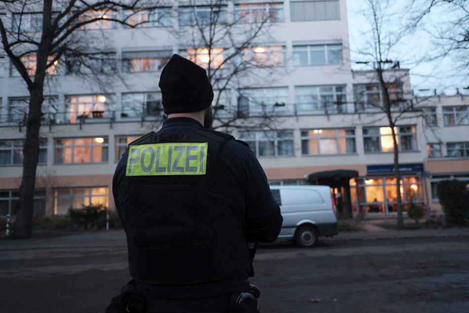 Ein Polizist steht vor dem Pflegeheim in der Stargardtstraße, in dem sich die Tat am Vormittag ereignet hat.