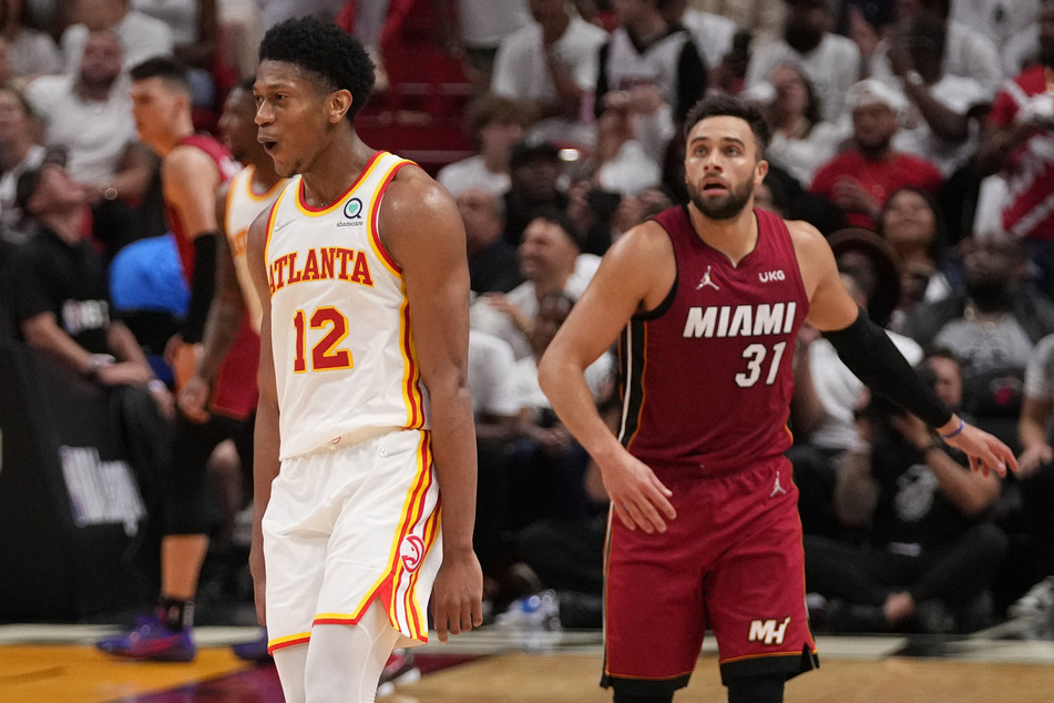 Atlanta Hawks forward De'Andre Hunter (l.) reacted after making a three point shot over Miami Heat guard Max Strus (r.) during the second half in game five of the first round for the 2022 NBA playoffs at FTX Arena.