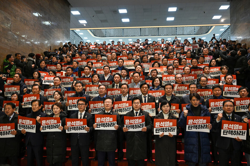 Opposition lawmakers held up signs reading "impeach Yoon Suk Yeol" and jeered as the members of the ruling party walked out of parliament.