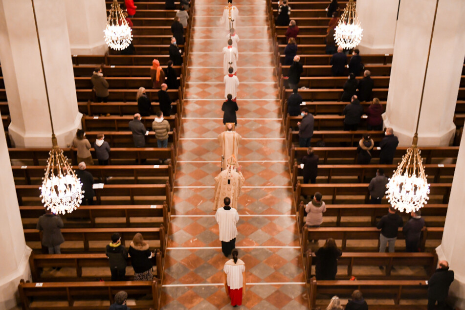 Kardinal Reinhard Marx (3.v.u.) beim Einzug zur Christmette an Heiligabend 2020 in der Frauenkirche (Liebfrauendom). Aufgrund von Infektionsschutzauflagen durften nur wenige Menschen den Gottesdienst besuchen und auf das Singen musste verzichtet werden.