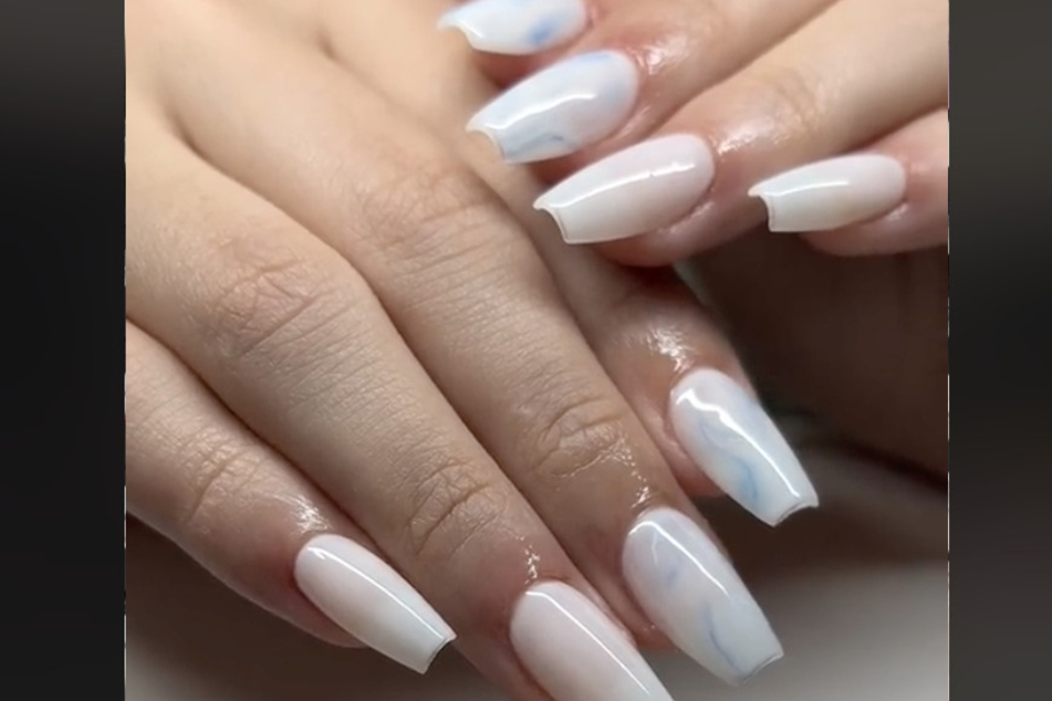 TikToker simplycutebydanic_ complied a cute clip of the top trending nail designs this spring, like this milky-white marble design on coffin-shaped nails.