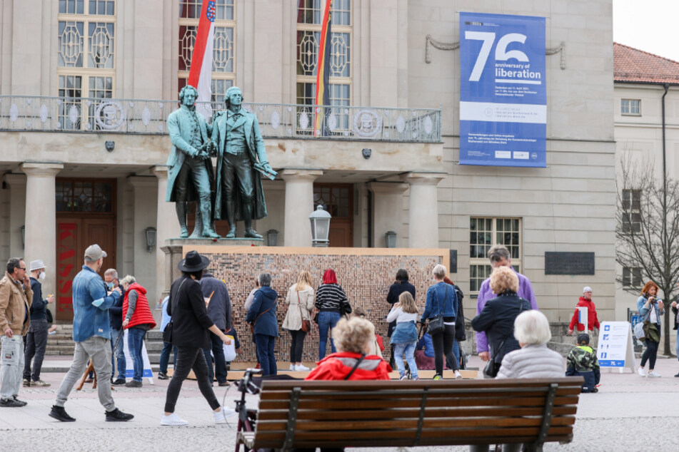 Zahlreiche Menschen stehen vor dem Theaterplatz mit dem Goethe-Schiller-Denkmal in Weimar. Die kreisfreien Städte Weimar und Suhl sind in Thüringen wieder die ersten beiden Gebiete mit einer Inzidenz unter 100.