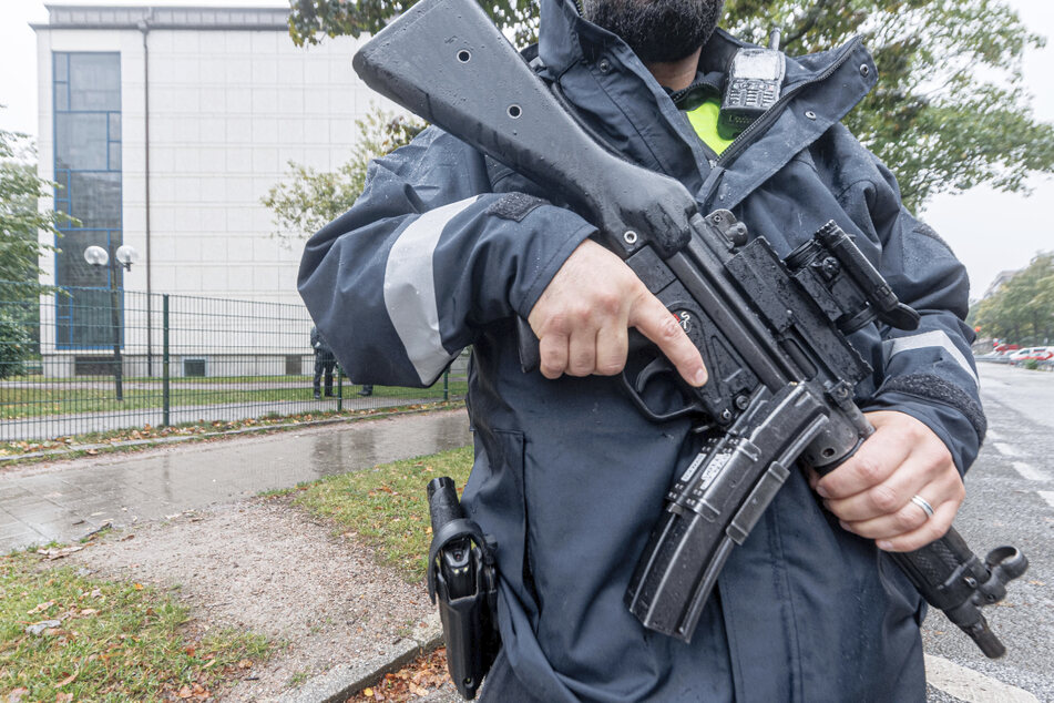 Ein schwerbewaffneter Polizist beschützt die Synagoge in Hamburg.