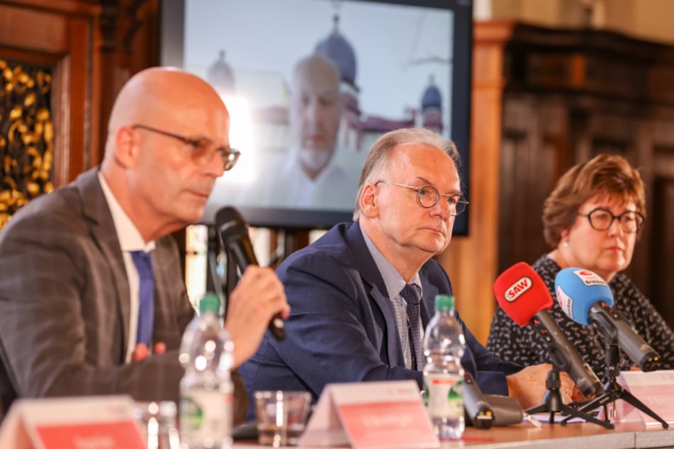 Halles Oberbürgermeister Bernd Wiegand (links) berät mit Petra Grimm-Benne (SPD), Sozialministerin Sachsen-Anhalt, und Reiner Haseloff (CDU), Ministerpräsident von Sachsen-Anhalt, über die Planung für das erste Jahresgedenken des Attentats von Halle. Max Privorozki, Präsident der Jüdischen Gemeinde Halle, ist per Video zugeschaltet.