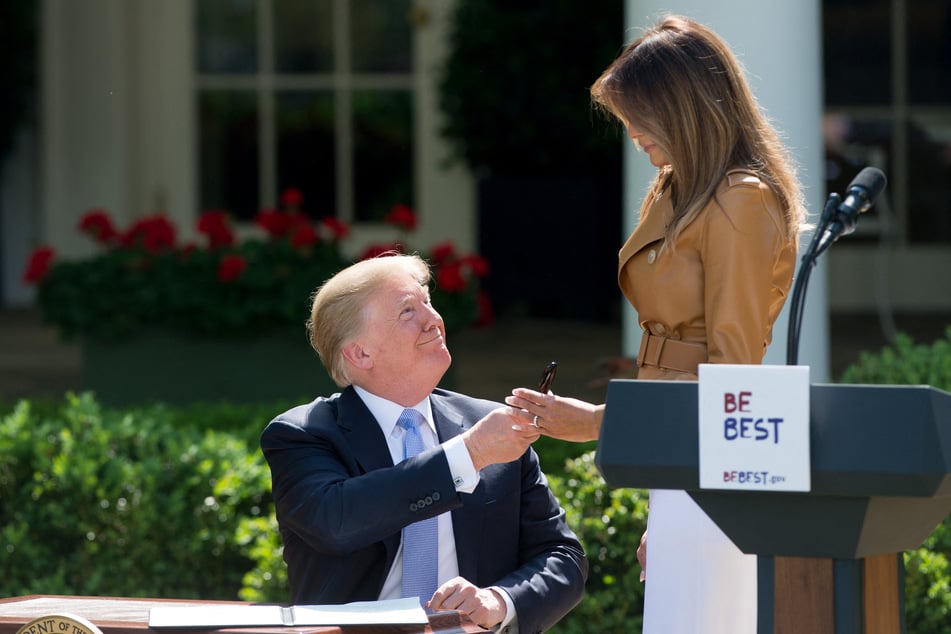 Then-President Donald Trump handing Melania Trump a pen after signing a proclamation in honor of her "Be Best" children's initiative on May 7, 2018.
