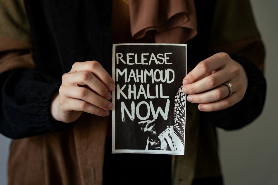 Dr. Noor Abdalla is pictured holding a sign reading "Release Mahmoud Khalil Now."