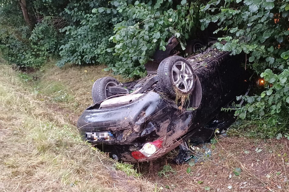 Der völlig zerstörte VW liegt nach dem Unfall auf dem Dach neben der Straße.