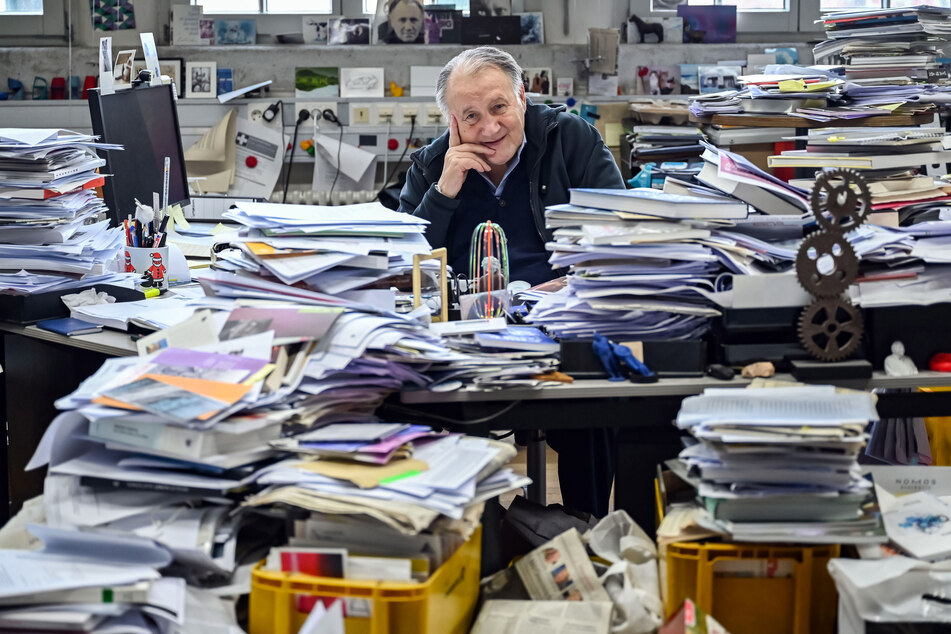 Peter Weibel (†78), Künstler und Direktor des Zentrums für Kunst und Medien (ZKM), sitzt in seinem Büro zwischen Stapeln aufgetürmten Papiers.
