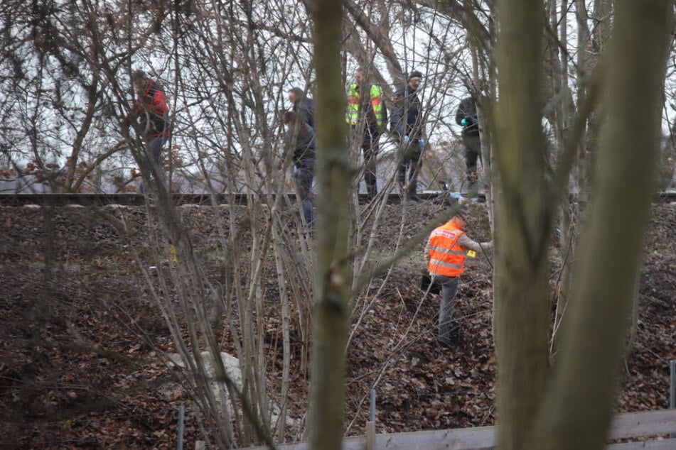 Nach einem Leichenfund an der Bahnstrecke Leipzig-Chemnitz sucht die Polizei vor Ort Spuren.