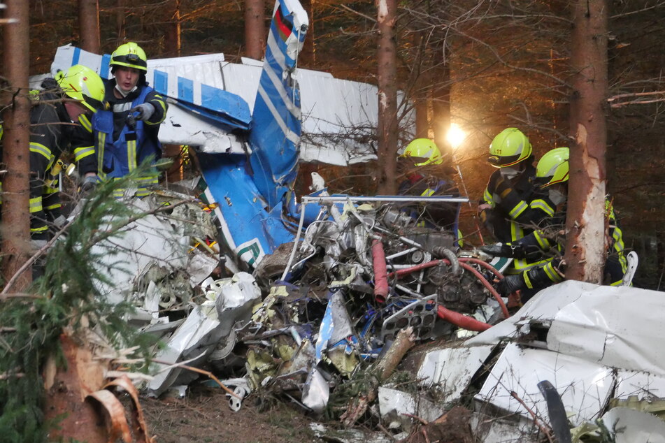 Einsatzkräfte arbeiten am Wrack eines kleinen Flugzeugs, das in ein Waldgebiet gestürzt ist. Vom Piloten oder Co-Piloten fehle noch jede Spur, ein Polizeihubschrauber sei für die Suche im Einsatz, sagte ein Polizeisprecher in Siegen.