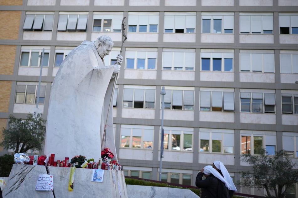 Zwei Nonnen halten ein Gebet vor dem Krankenhaus, in dem Papst Franziskus behandelt wird.